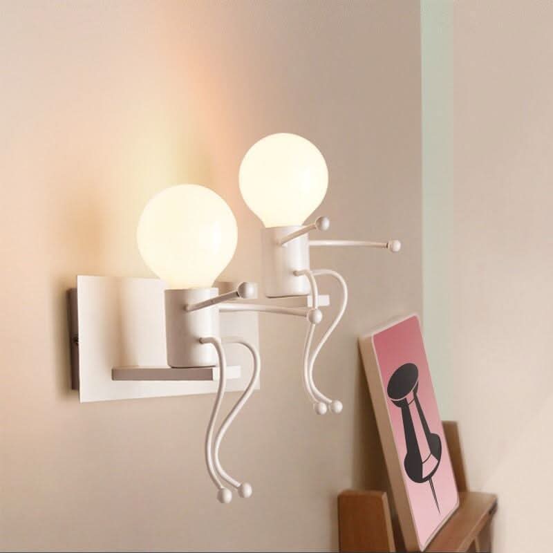 Applique murale blanche à deux globes allumés sur fond beige, œuvre rose posée à droite.