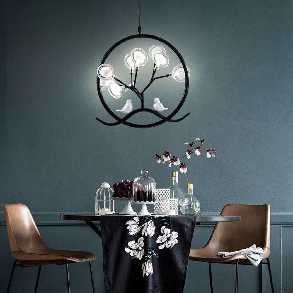 Suspension noire allumée au-dessus d'une table dressée, ambiance salle à manger.