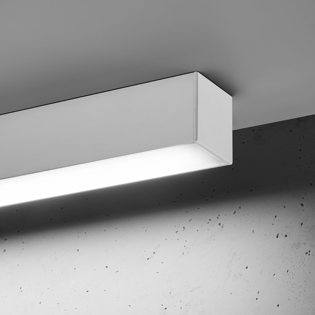 Vue rapprochée du luminaire allumé montrant le diffuseur inférieur et la lumière.