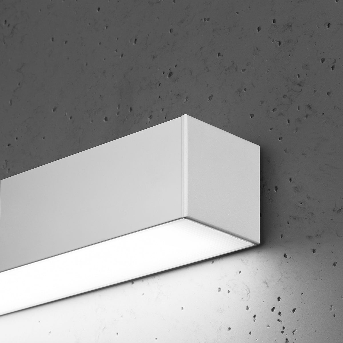 Gros plan sur l'angle du boîtier blanc et la lumière rasante émise
