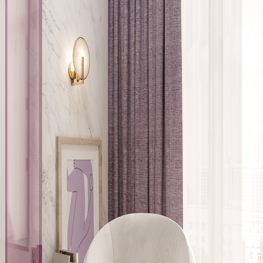 Mise en ambiance de l'applique allumée sur un mur en marbre près d'un rideau violet