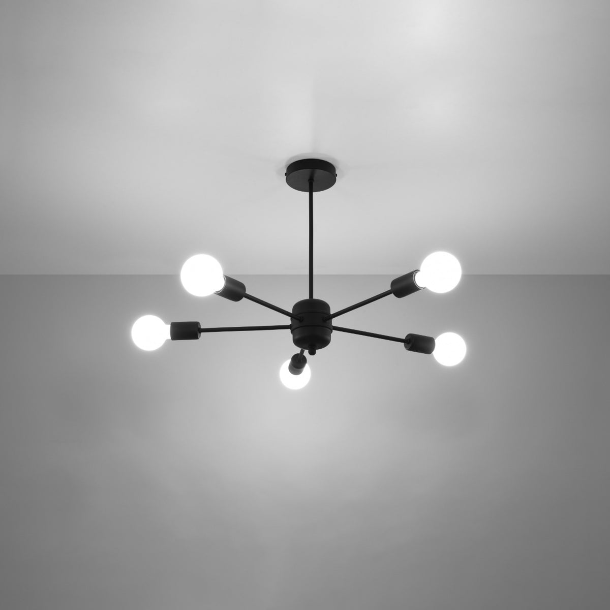 Luminaire allumé au plafond, cinq ampoules blanches diffusant une lumière douce.