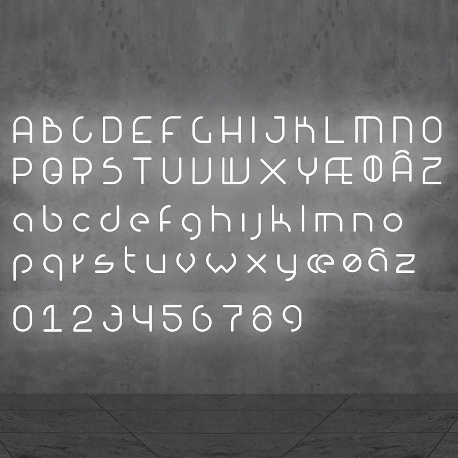 Alphabet complet et chiffres lumineux blancs disposés sur un mur béton gris.