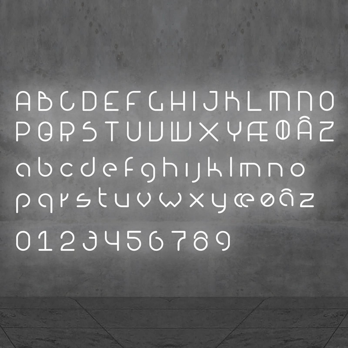 Alphabet complet et chiffres lumineux blancs alignés sur un mur béton, vue frontale