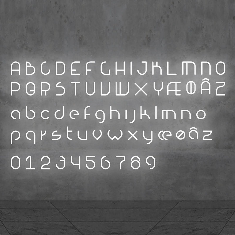 Alphabet complet et chiffres lumineux blancs alignés sur un mur béton, vue frontale