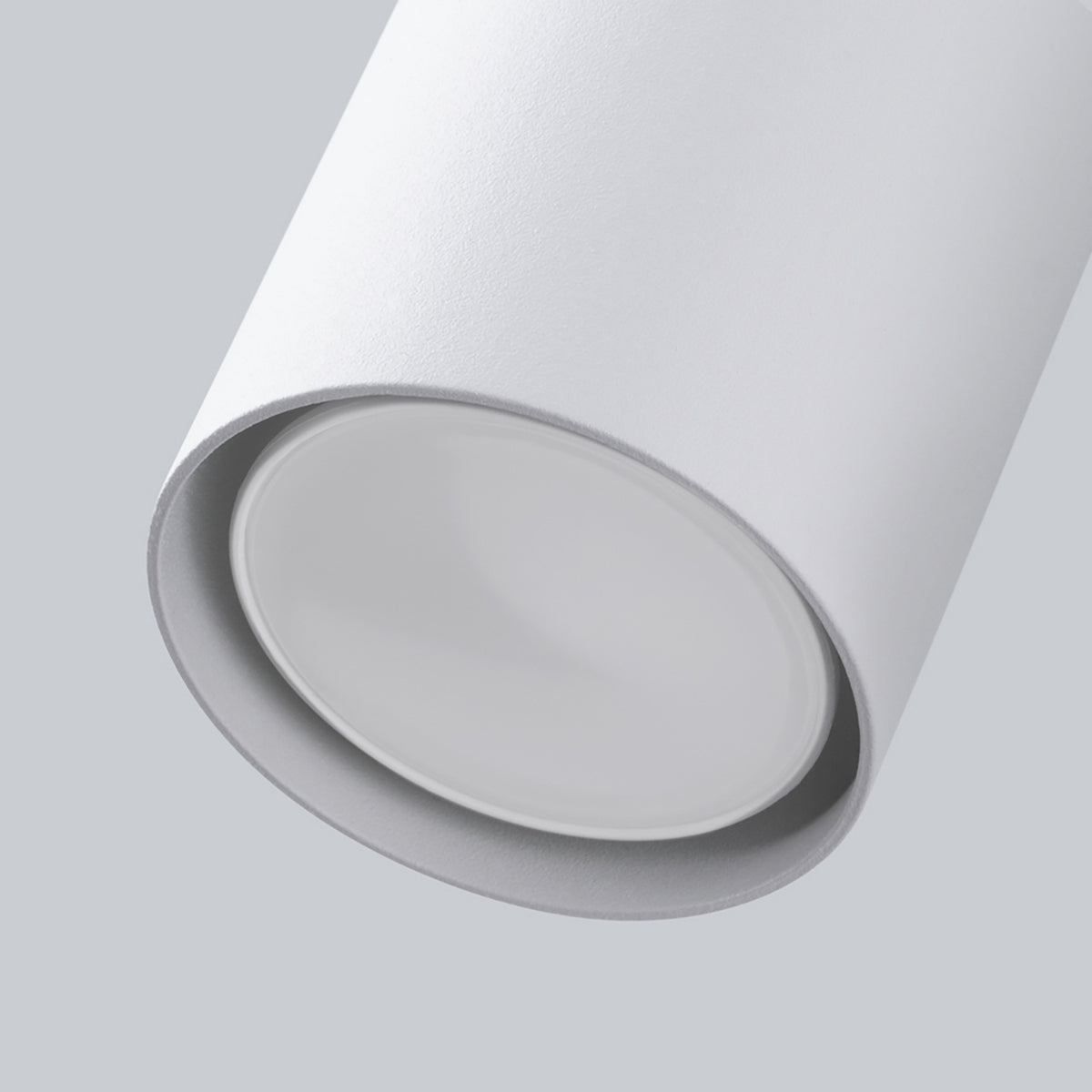 Détail rapproché de la tête cylindrique et du diffuseur blanc de l'applique.