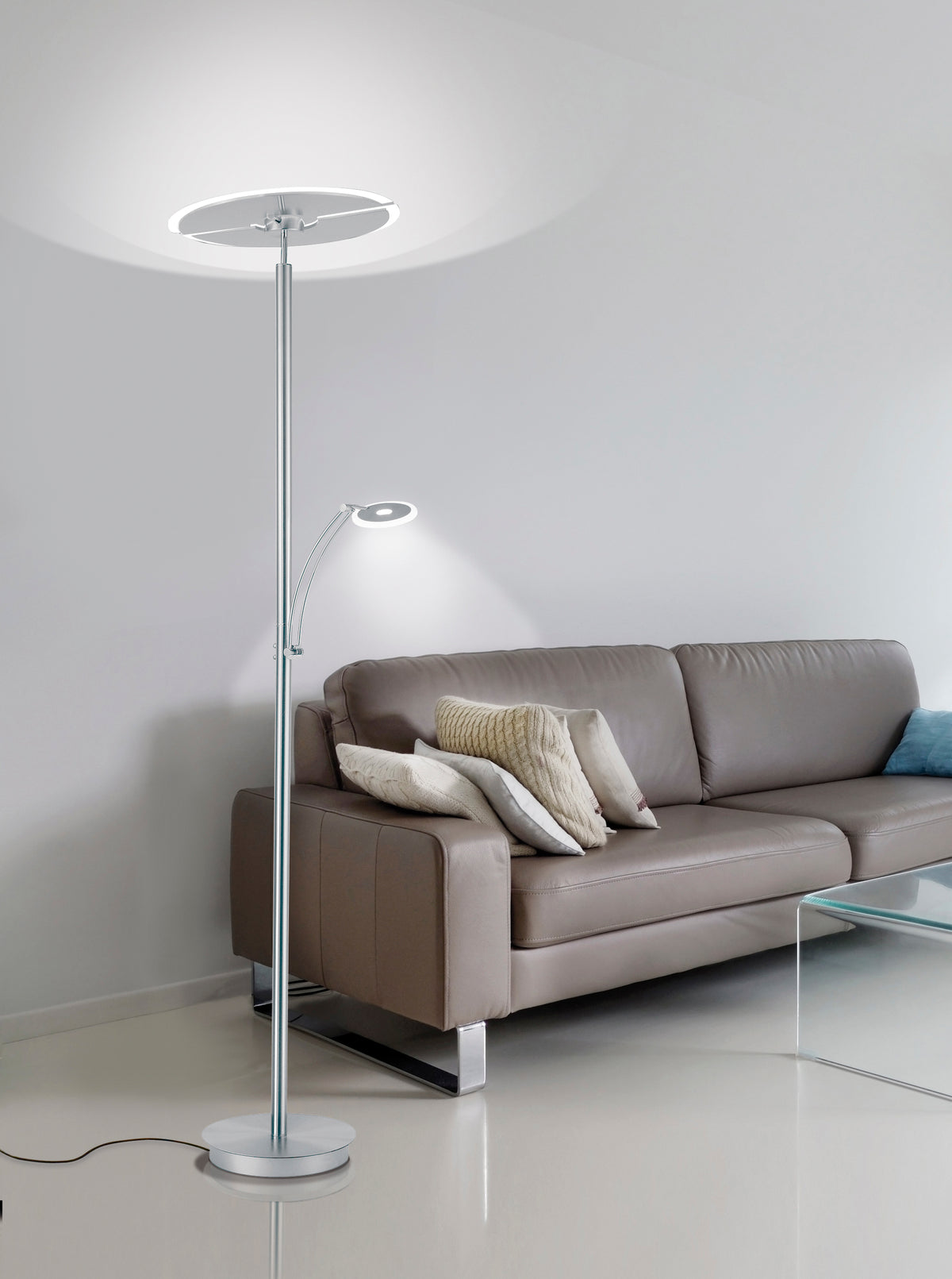 Mise en ambiance dans un salon avec canapé, le lampadaire éclaire le plafond.