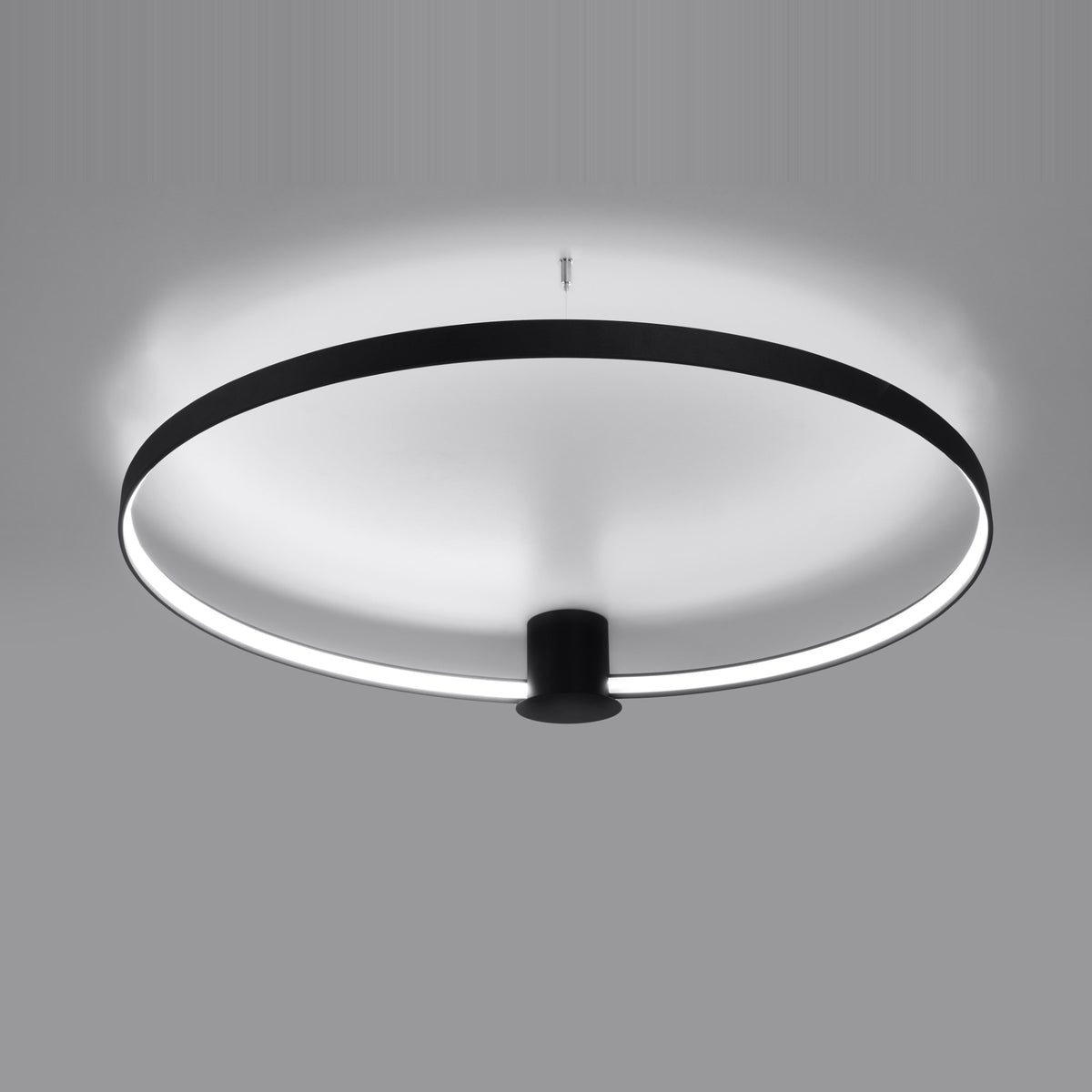 Mise en ambiance sombre, halo lumineux diffusé par l'anneau suspendu.