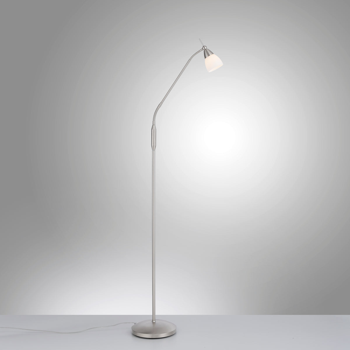 Lampadaire allumé sur fond gris, câble visible, halo lumineux diffus.