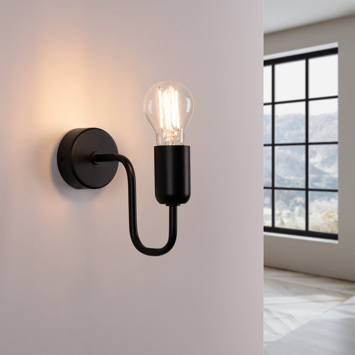 Applique murale noire allumée diffusant une lumière chaude sur le mur