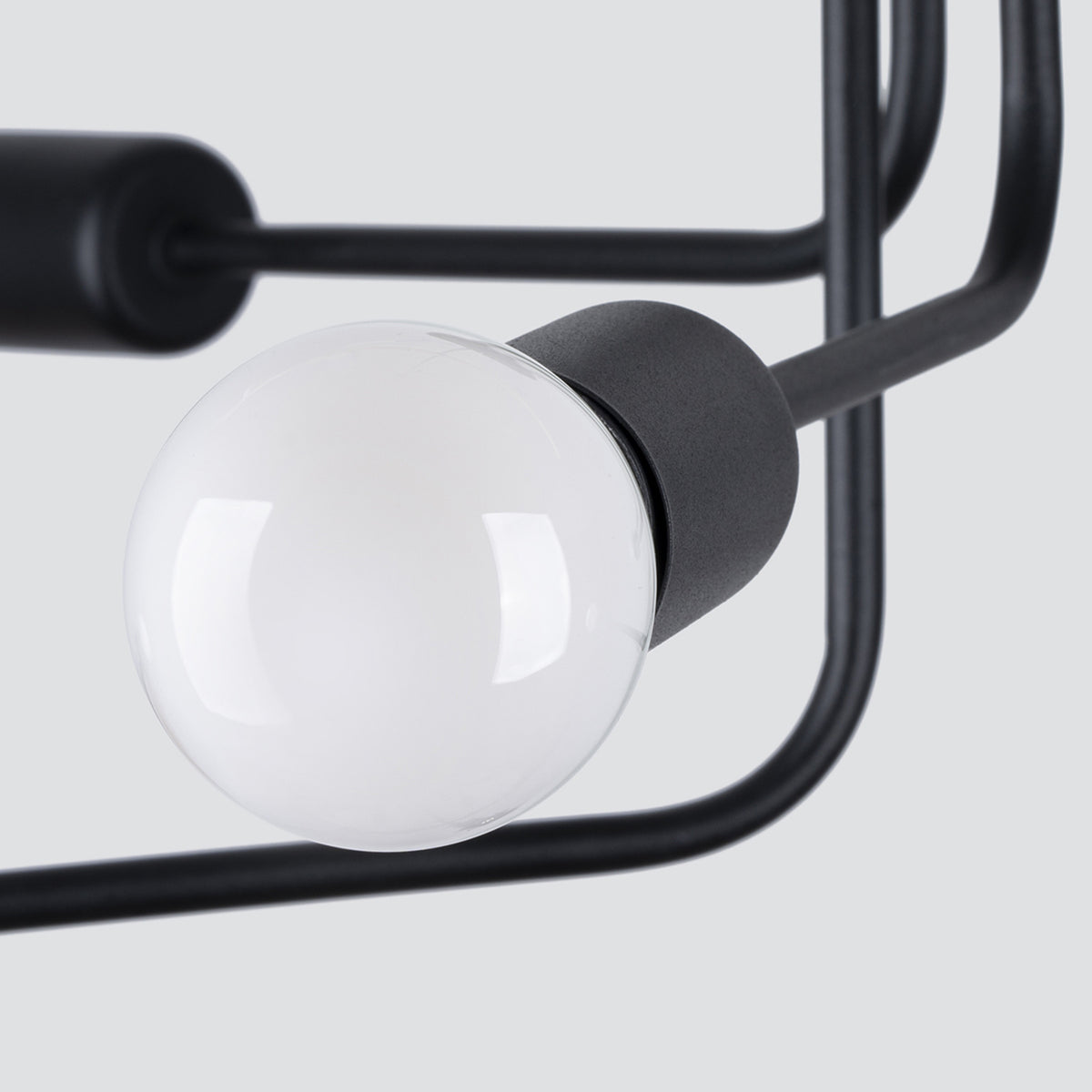 Détail rapproché d'une douille cylindrique noire et de son globe de verre brillant