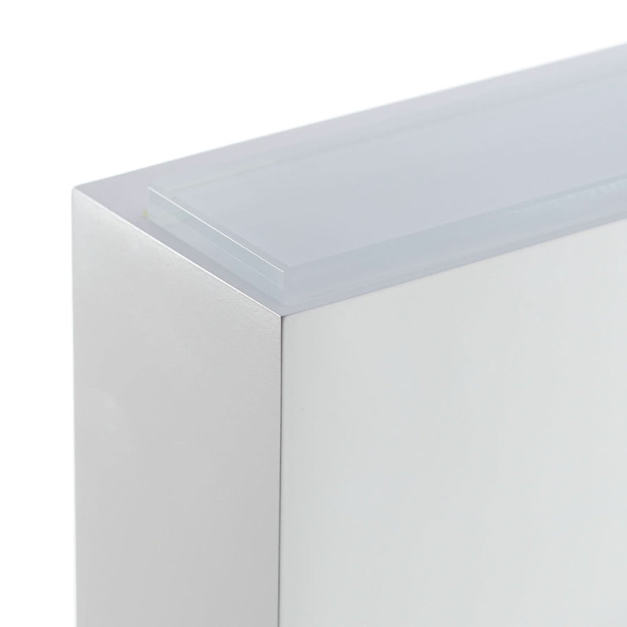Détail d’angle montrant l’épaisseur du verre et la finition mate blanche.