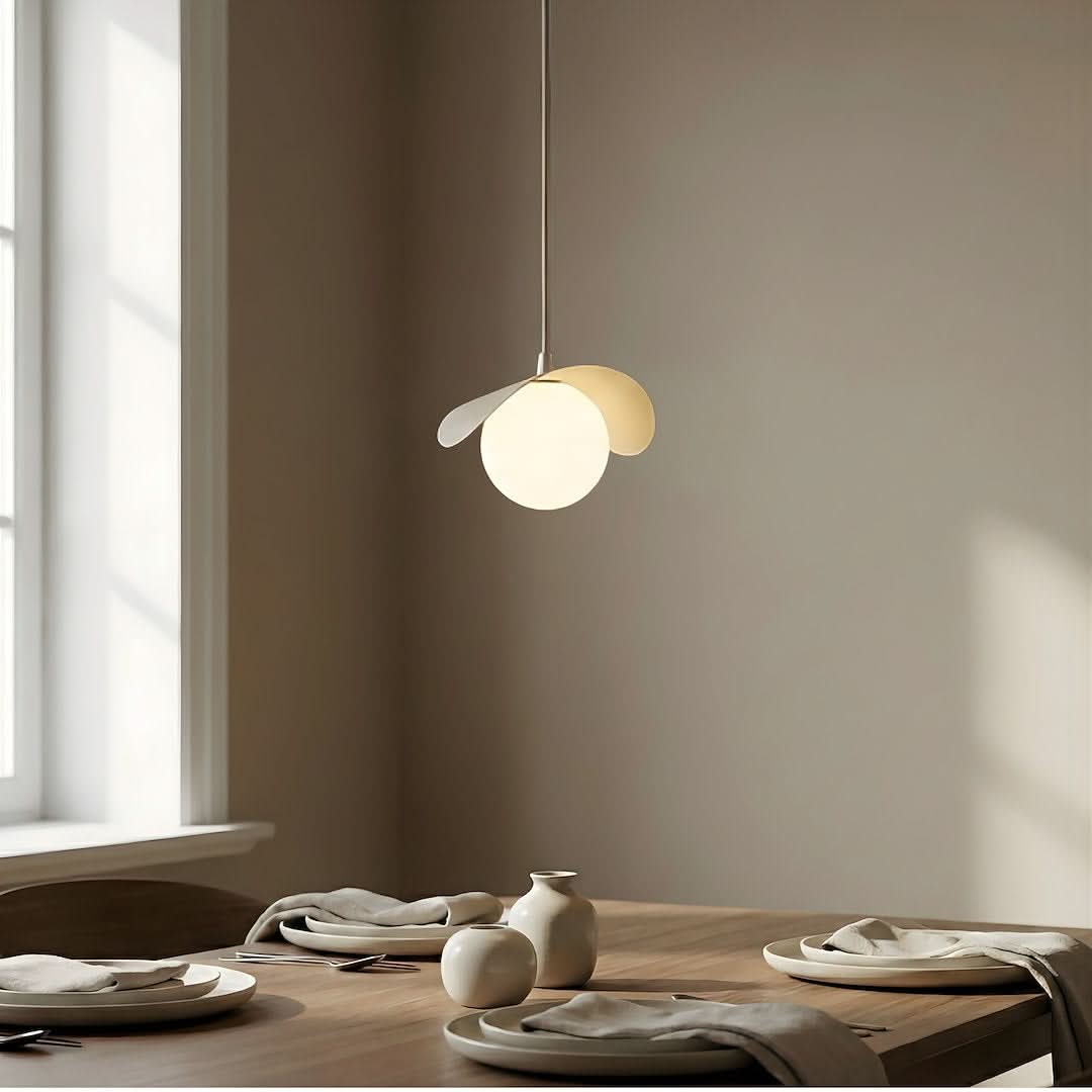 Détail de la suspension allumée au-dessus d'une table dressée près d'une fenêtre
