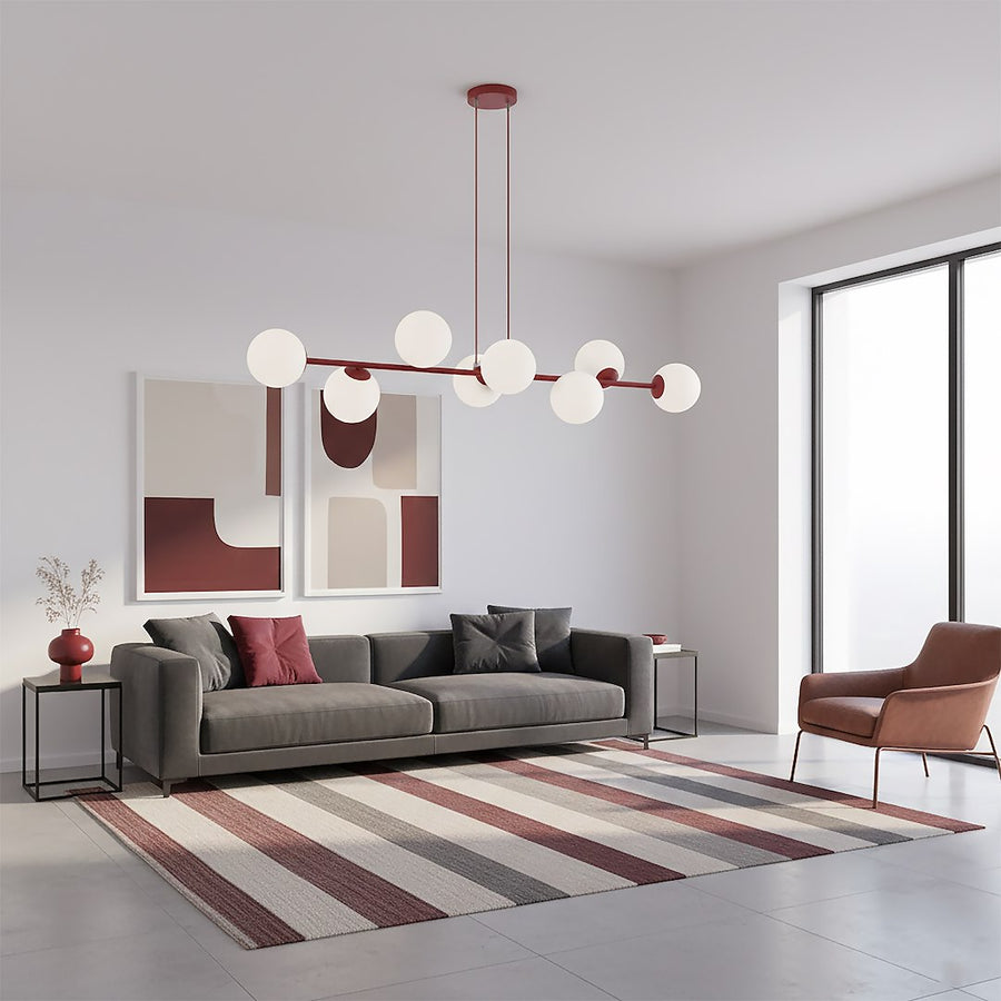 Suspension dans un salon moderne, canapé gris, grande fenêtre et tapis rayé multicolore.