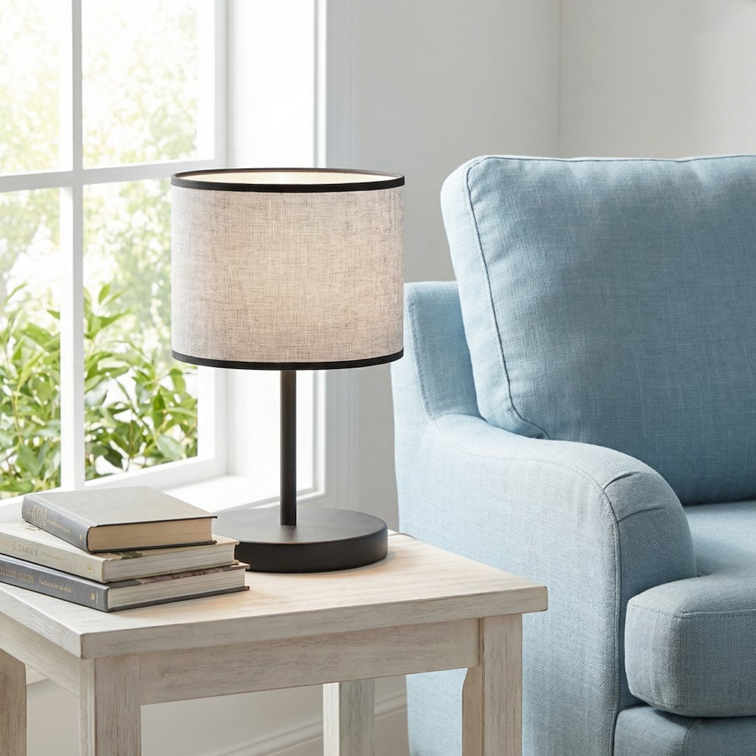 Mise en ambiance salon : lampe posée sur table d'appoint près d'un fauteuil bleu