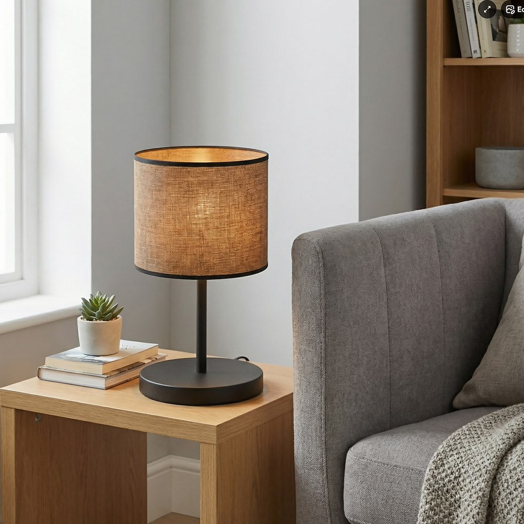 Mise en ambiance salon : lampe allumée sur table d'appoint en bois clair