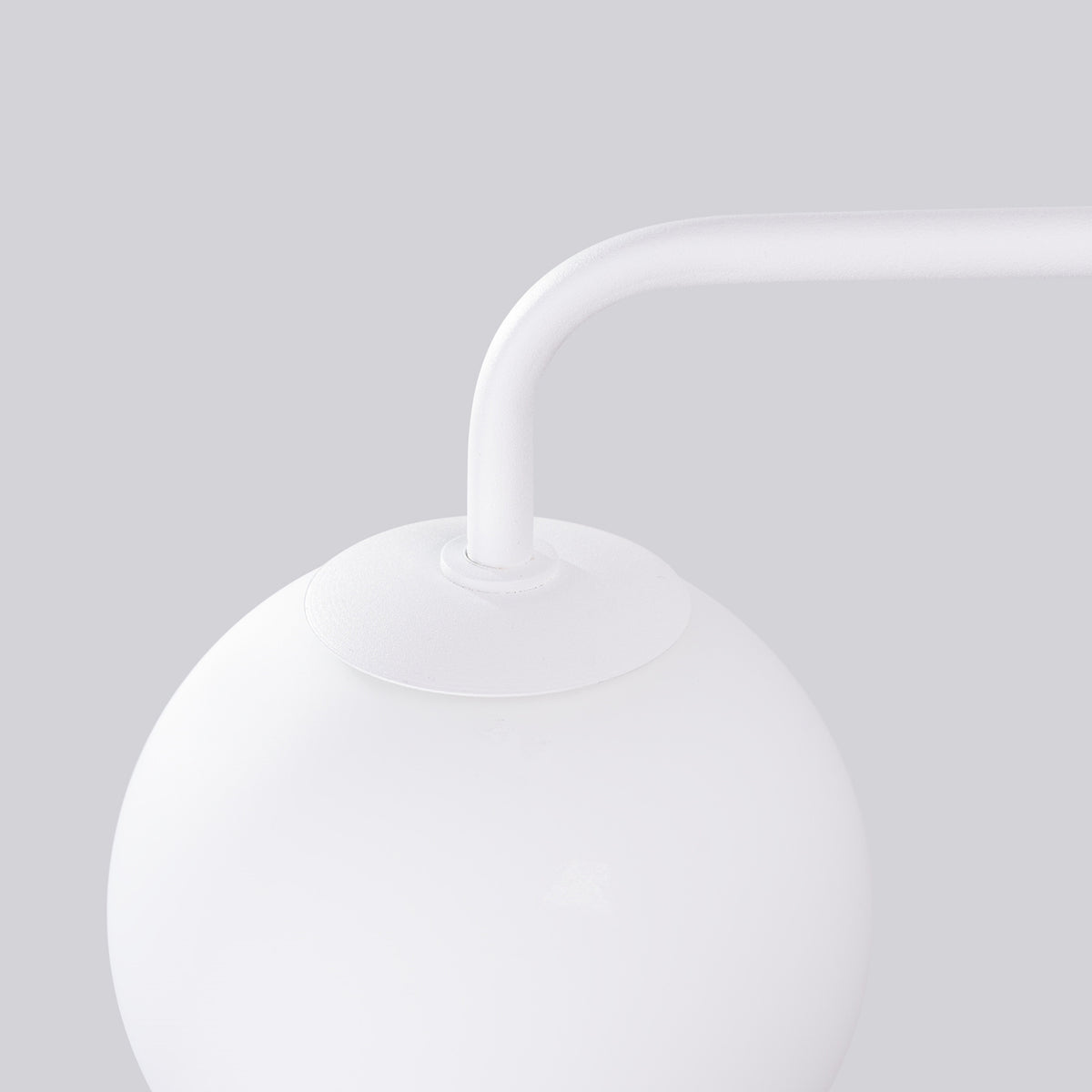 Détail du raccord entre le bras courbé et le globe en verre opalin blanc.