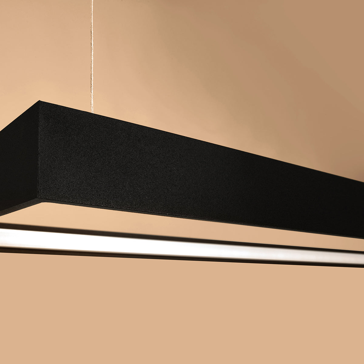 Gros plan sur l'angle du cadre noir, finition granuleuse et diffuseur blanc.