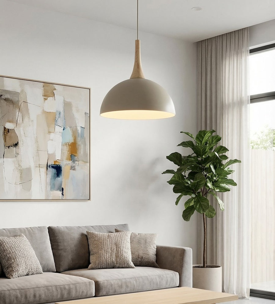 Luminaire suspendu au-dessus d'un canapé gris, tableau abstrait et plante verte