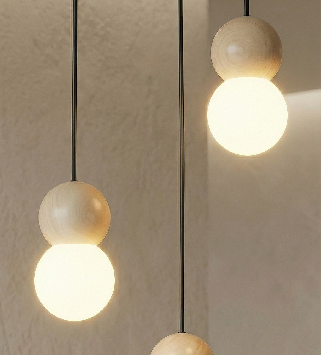Détail rapproché d'une sphère en bois clair surmontant un globe de verre opalin