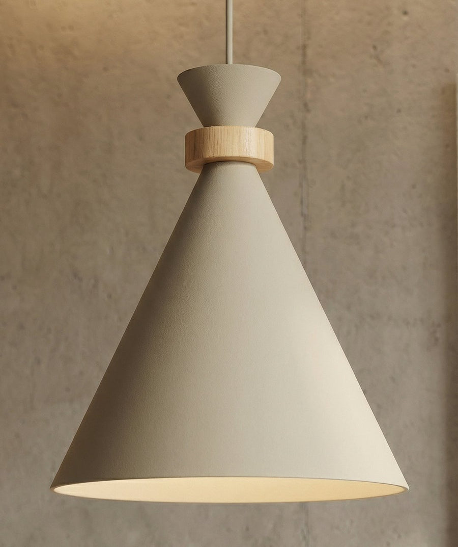 Détail rapproché de l'abat-jour conique beige et de la bague en bois clair