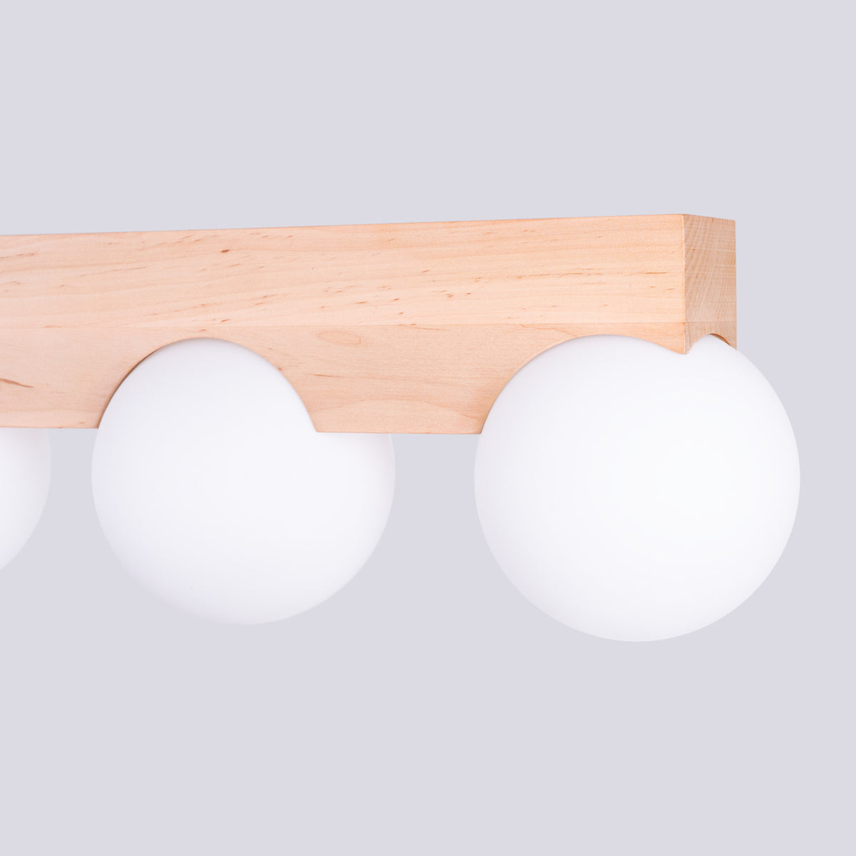 Détail de la structure en bois avec découpes et globes blancs, vue de côté.
