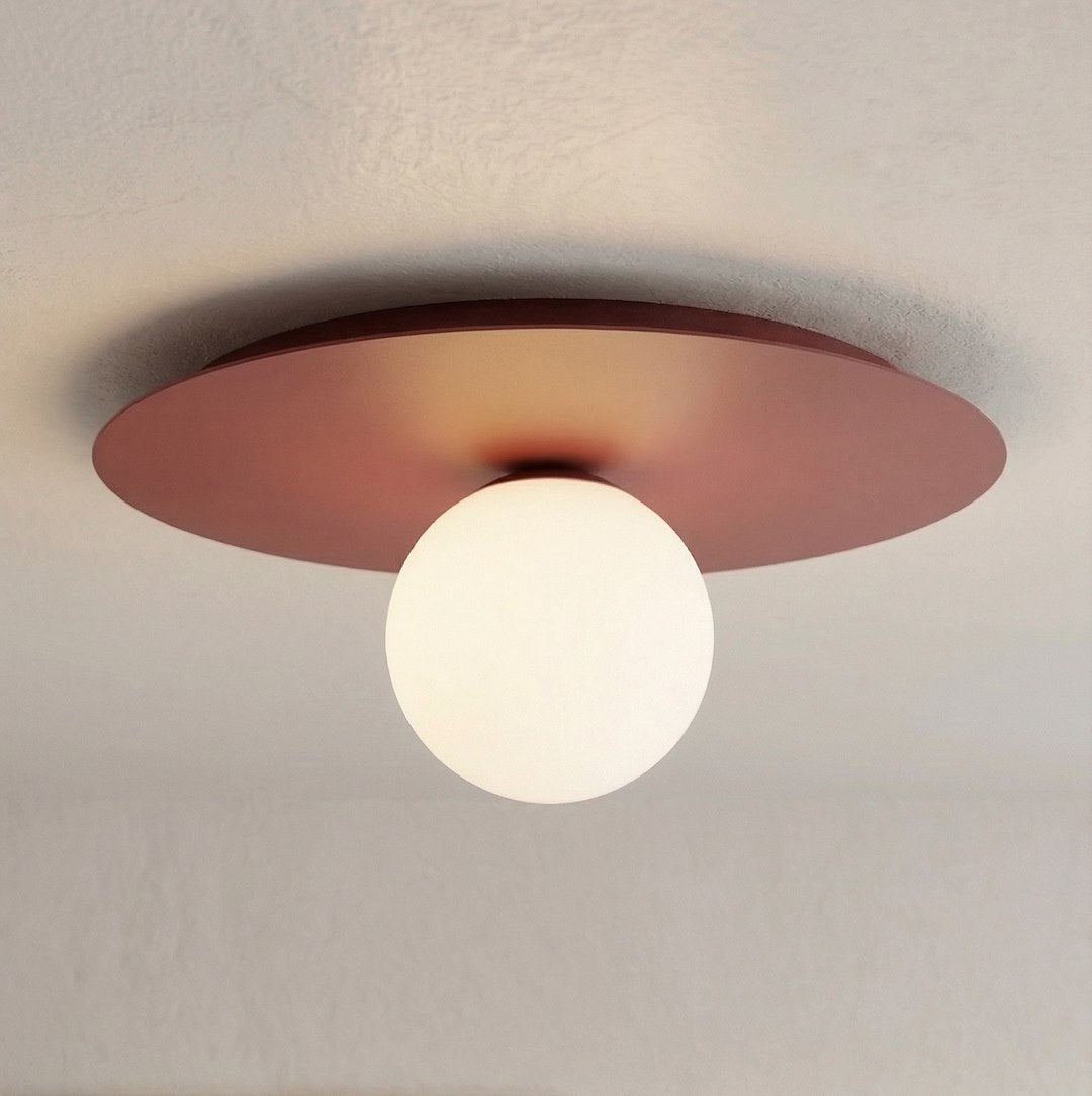 Plafonnier allumé fixé au plafond, globe blanc diffusant une lumière chaude