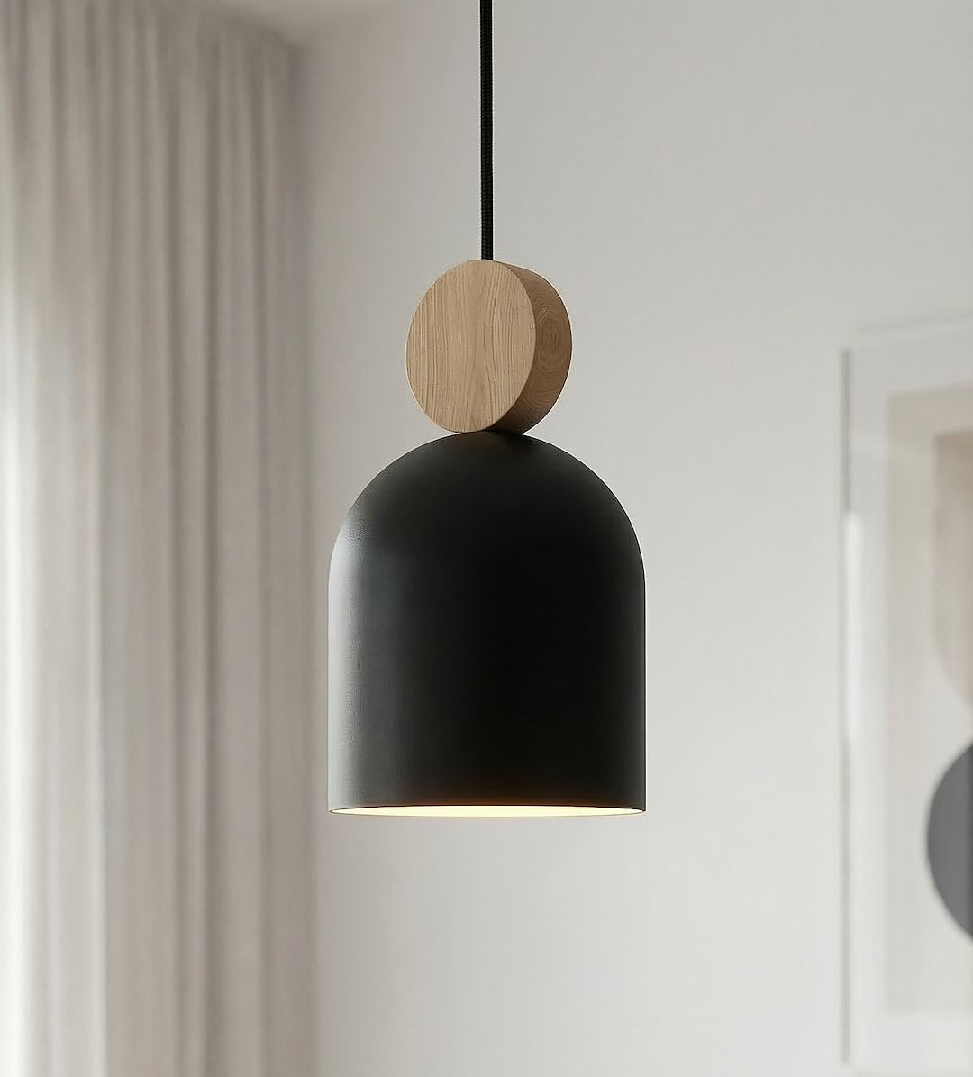 Détail d'un abat-jour noir mat surmonté d'un disque en bois clair