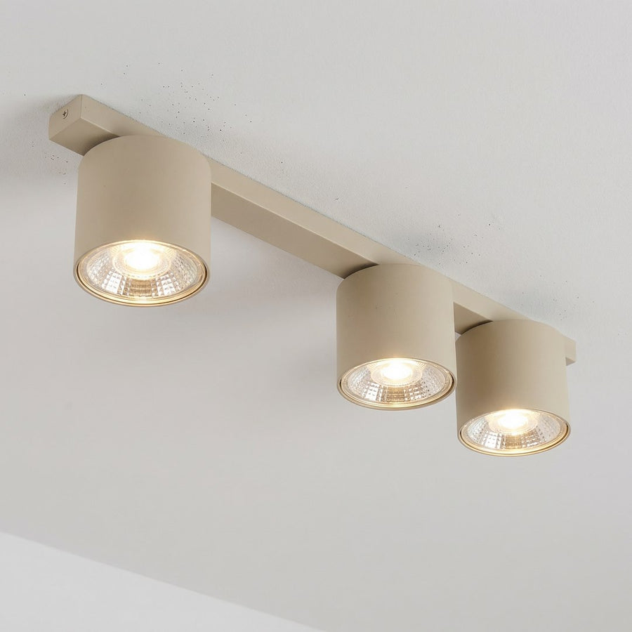 Détail des spots allumés et de leur halo lumineux chaud sous le plafond