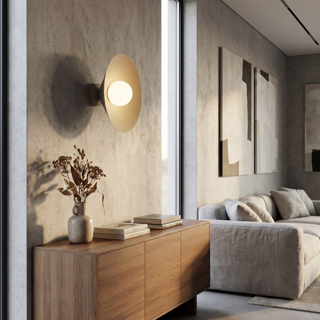 Mise en ambiance dans un salon, applique allumée au-dessus d'un meuble en bois