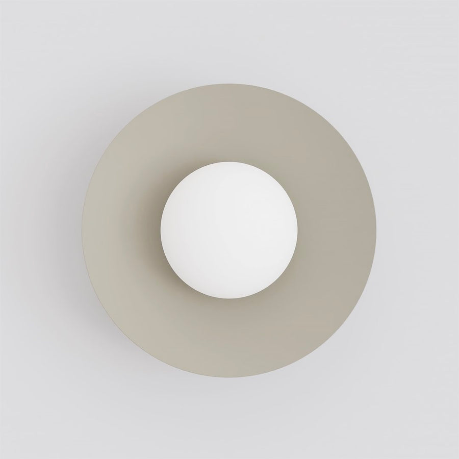 Vue de face du luminaire, grand disque beige et sphère blanche centrale.