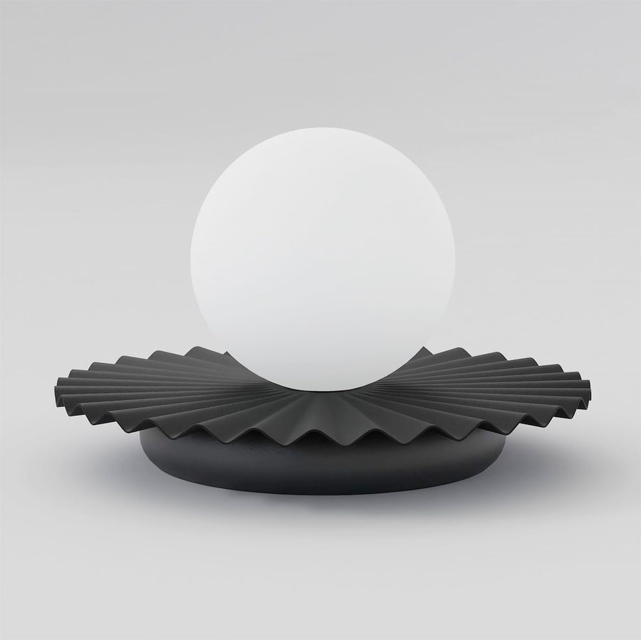 Lampe à poser vue de face, sphère de verre blanc sur socle plissé noir