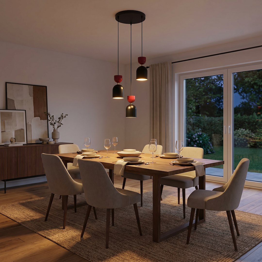 Suspension allumée au-dessus d'une table dressée dans une salle à manger le soir.