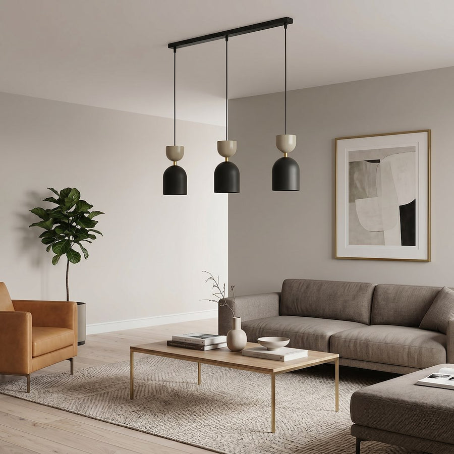 Ambiance salon contemporain, trio de suspensions devant un mur beige et un fauteuil cuir