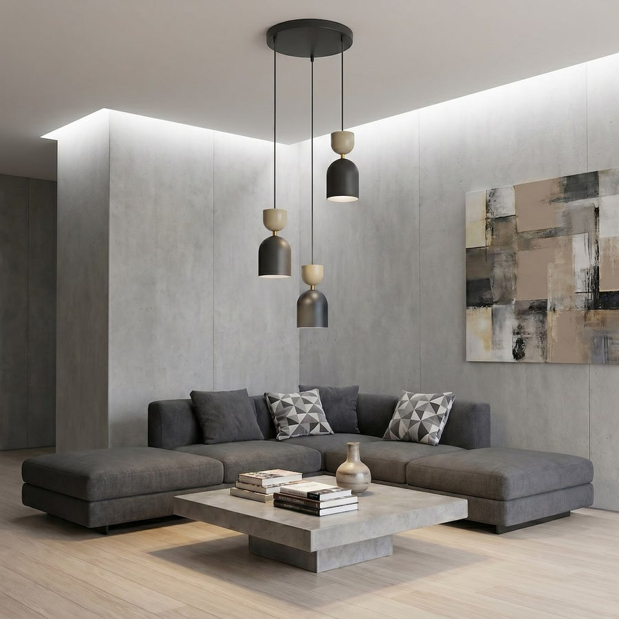 Mise en ambiance dans un salon contemporain, canapé gris et mur béton, suspension allumée