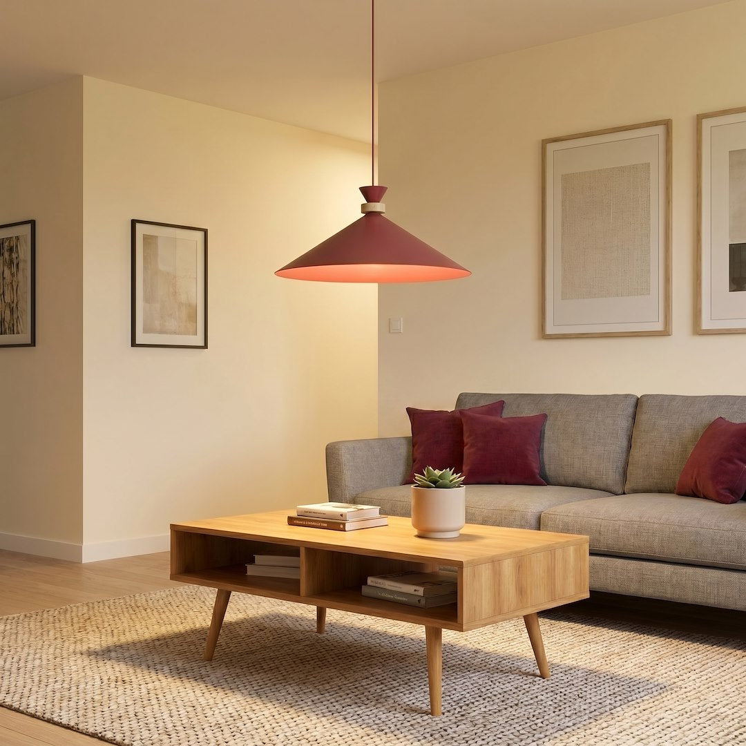 Luminaire allumé au-dessus d'un salon gris avec coussins et table basse claire