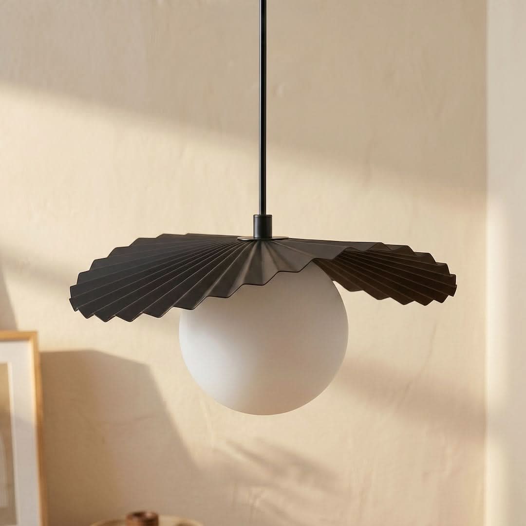 Détail rapproché de l'abat-jour plissé noir et du globe de verre blanc