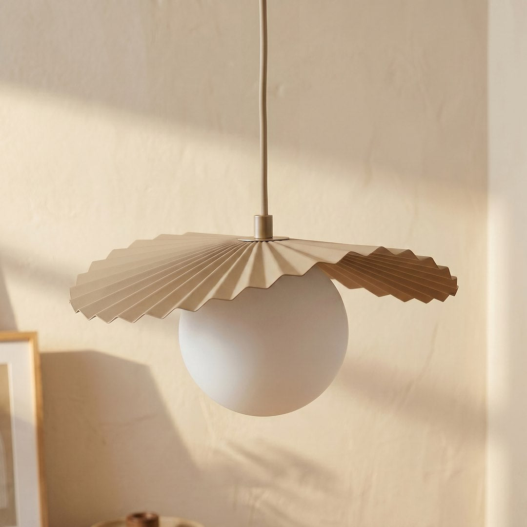 Détail rapproché d'un globe blanc surmonté de son abat-jour plissé beige
