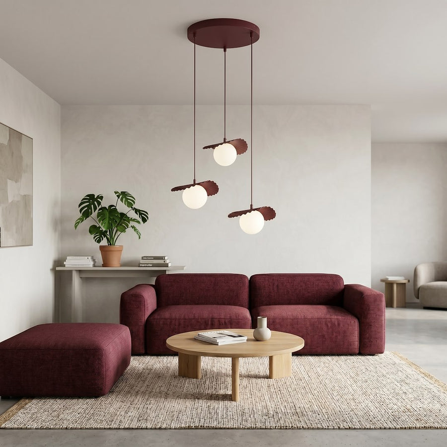 Ambiance salon moderne, suspension allumée au-dessus d'un canapé bordeaux