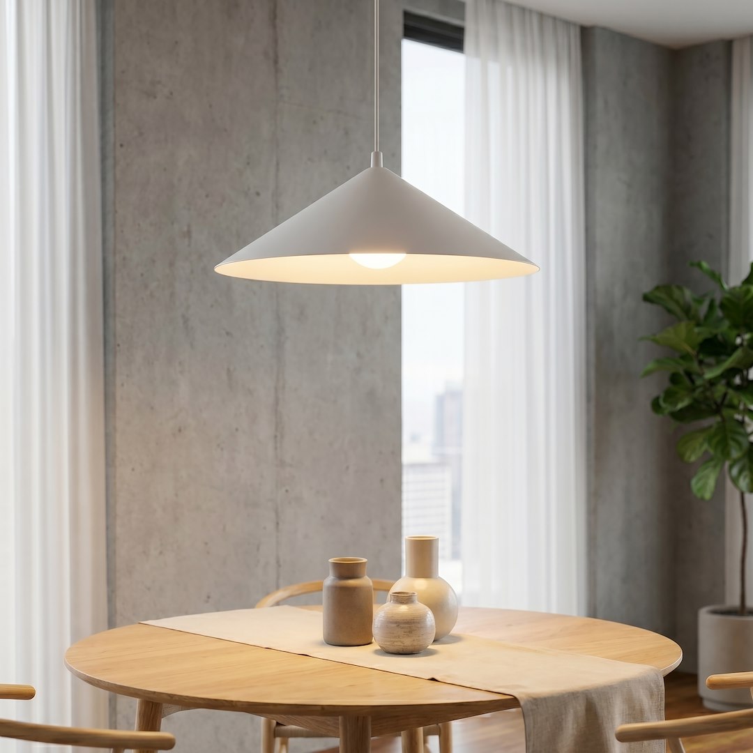 Gros plan sur l'abat-jour conique diffusant une lumière chaude sur la table