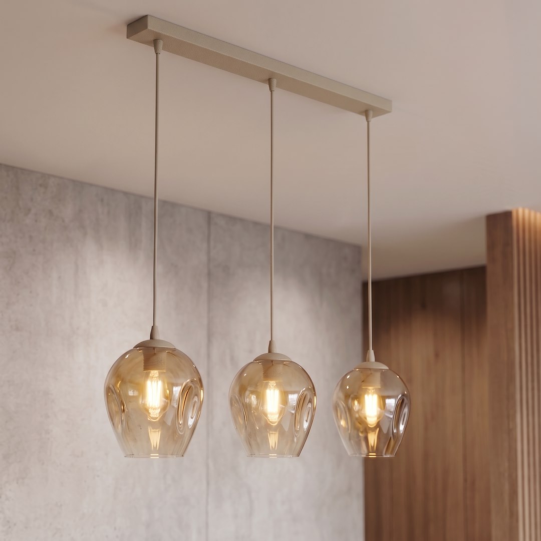 Vue en intérieur : suspension fixée au plafond, trois globes ambrés devant mur béton et bois.