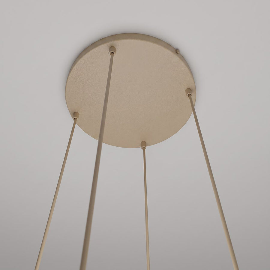 Détail du pavillon circulaire beige fixé au plafond avec quatre câbles tendus
