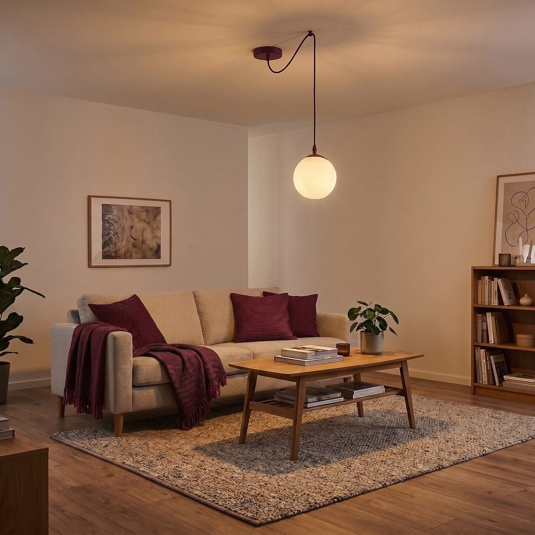 Vue en ambiance le soir, suspension ronde diffusant une lumière chaude sur le salon