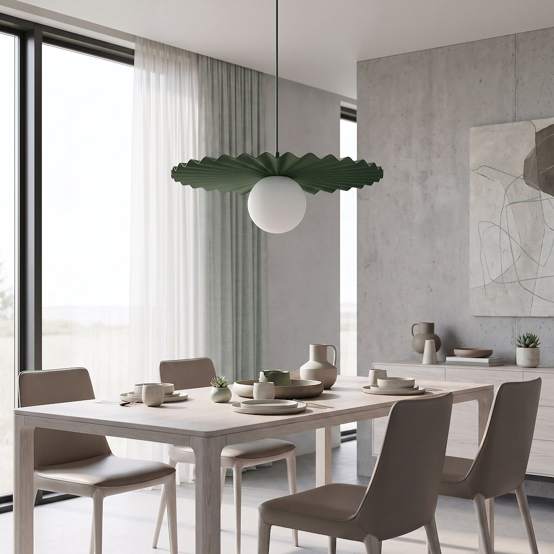 Pièce à vivre lumineuse, abat-jour plissé vert et boule blanche au-dessus de la table