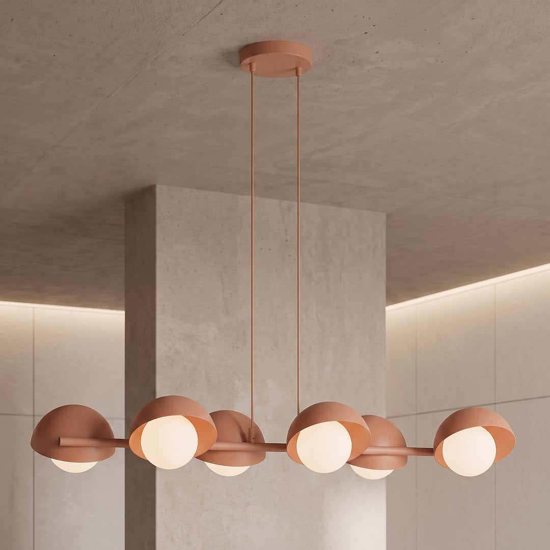 Luminaire suspendu au plafond en béton, montrant tiges fines et diffuseurs lumineux allumés.