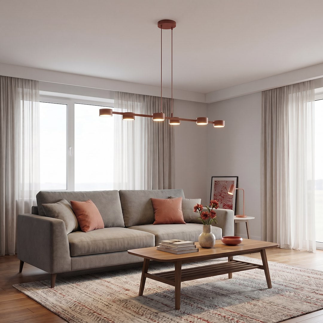 Mise en ambiance dans un salon moderne avec canapé gris et coussins corail