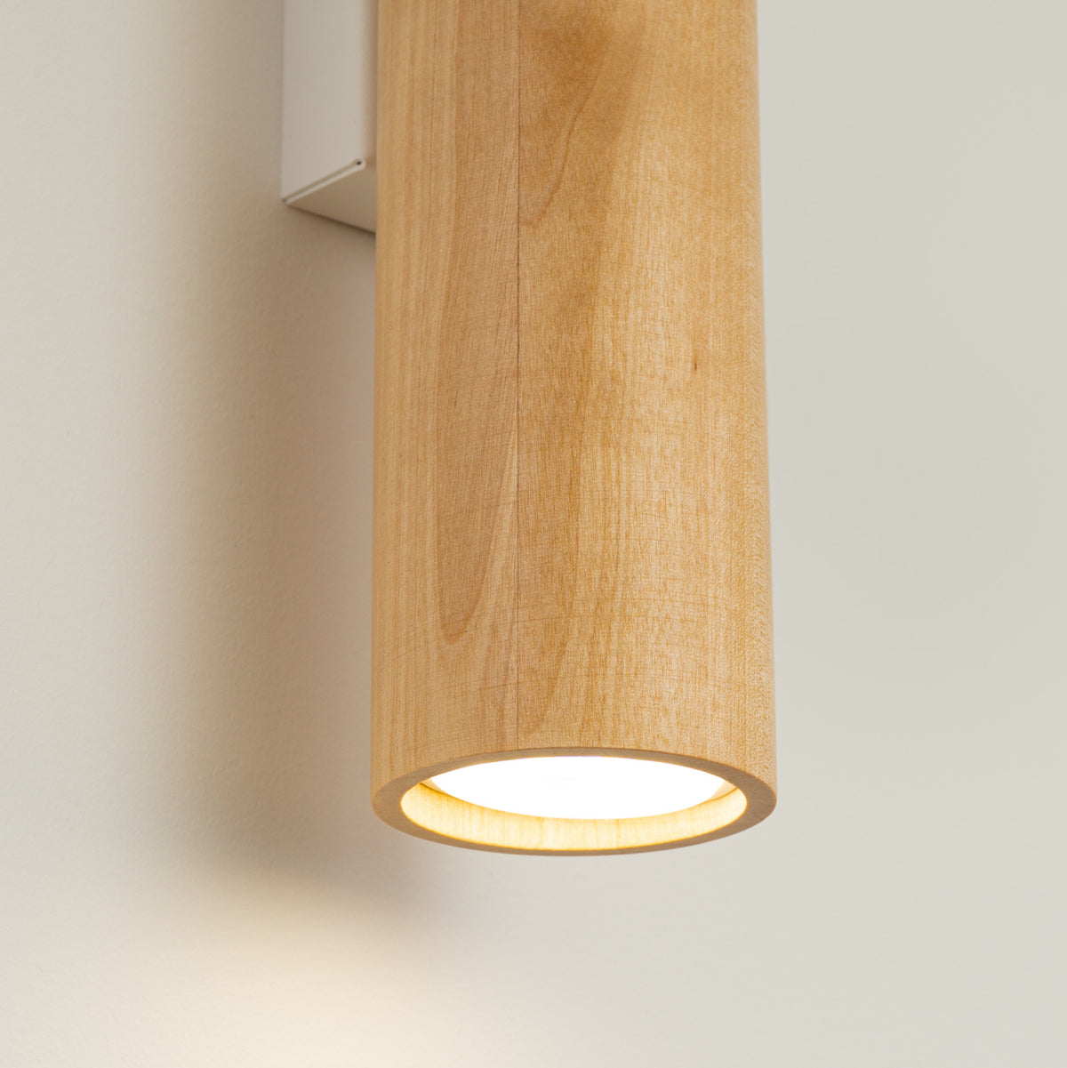 Détail du bas du cylindre en bois, ouverture éclairée par une lumière chaude