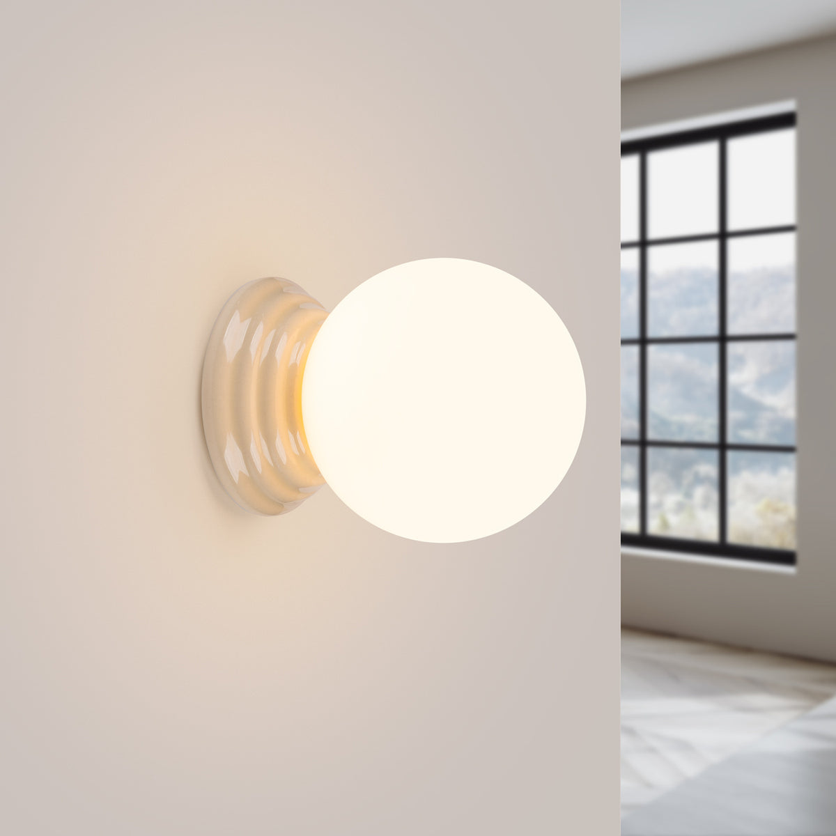 Applique murale allumée sur un mur beige, halo lumineux chaud près d'une fenêtre.