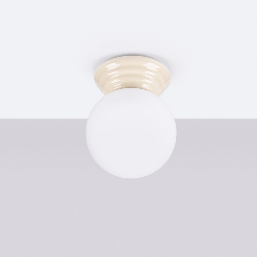 Plafonnier monté au plafond, éteint, globe blanc et base ivoire.