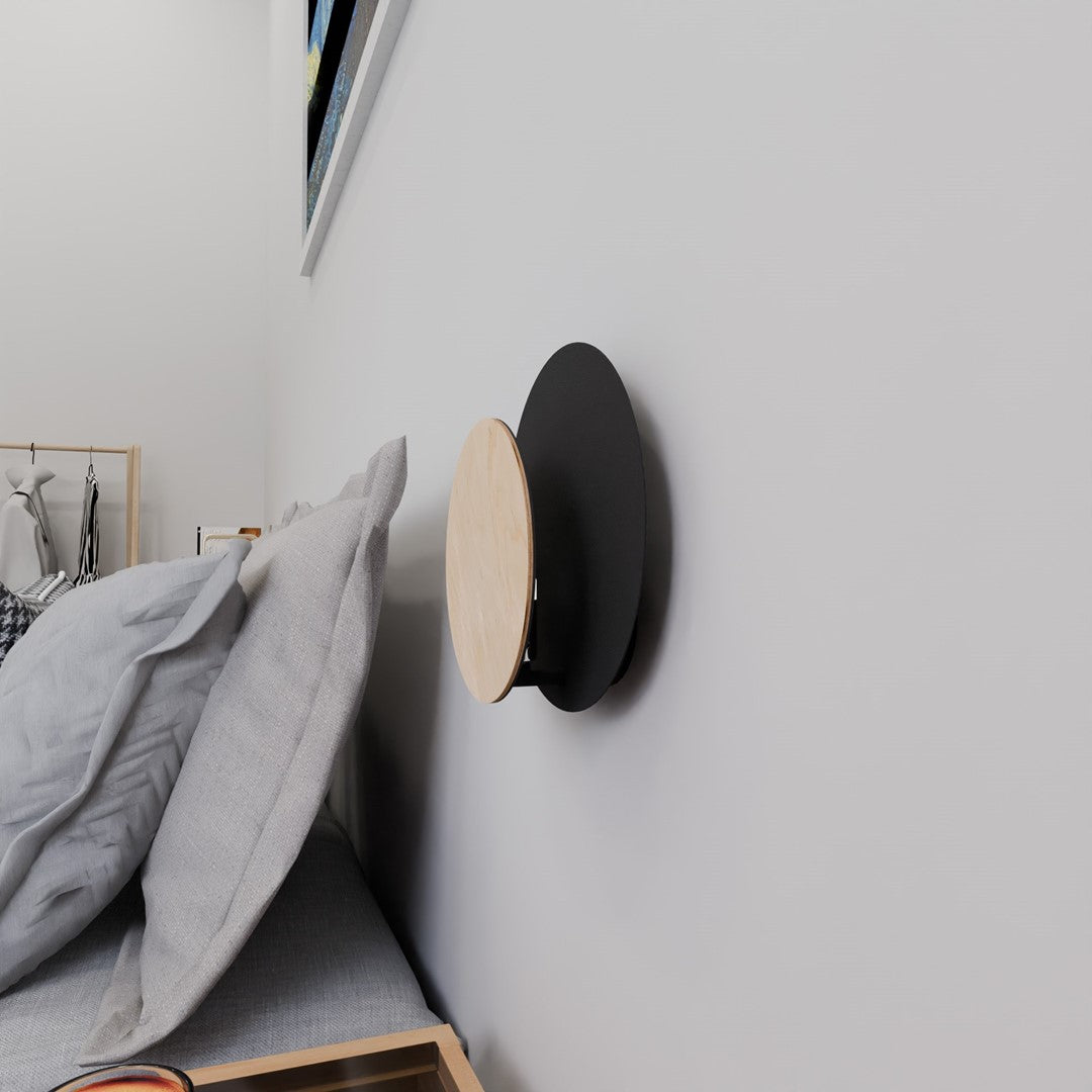 Applique fixée au mur près d'un lit, montrant son déport latéral